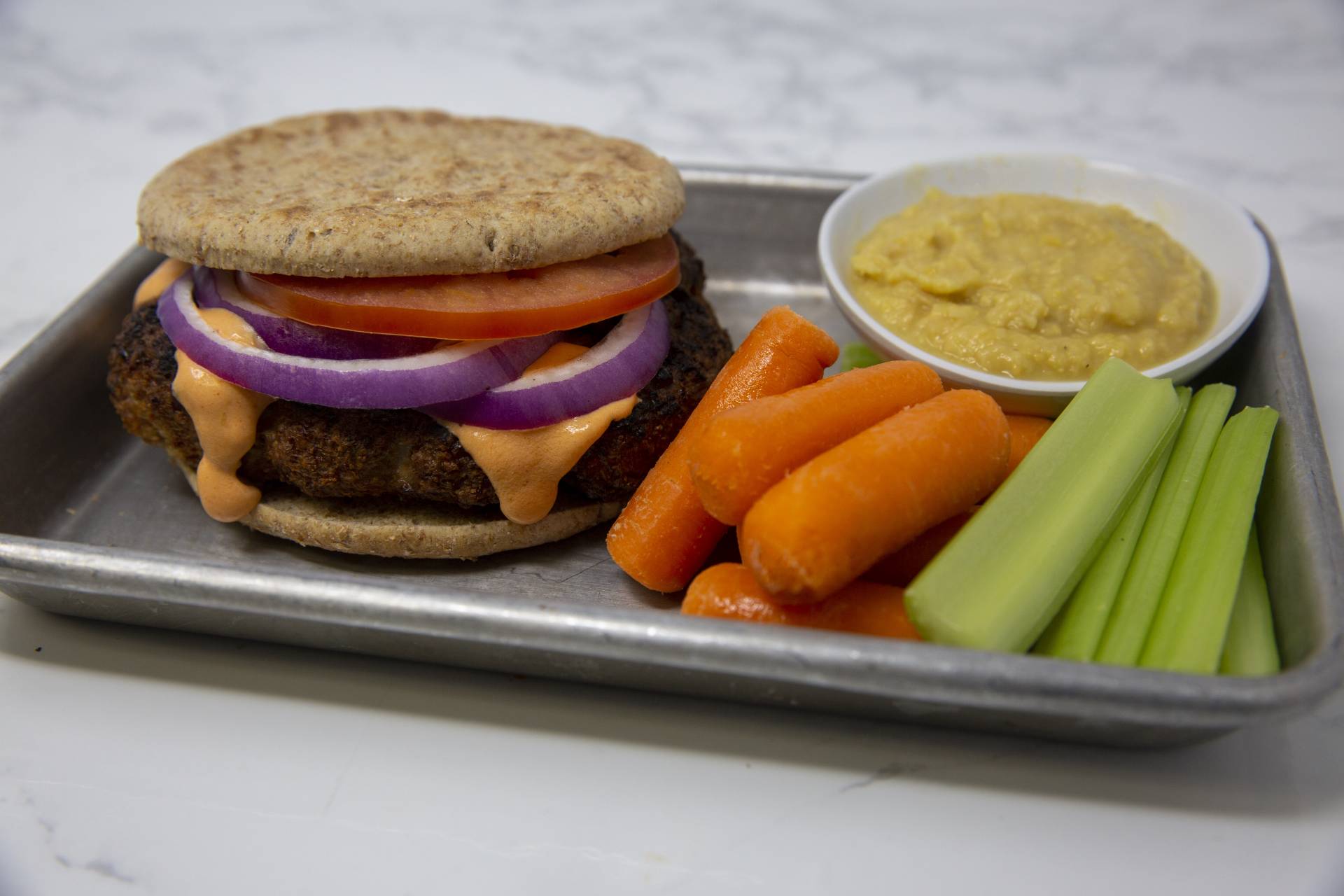 Buffalo Turkey Burger with Hummus and Vegetables.
